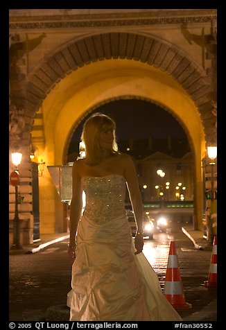 Woman in bridal gown in front of the Louvre by night. Paris, France (color)