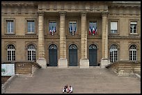 Two tourists sitting on the stairs of the Palais de Justice. Paris, France (color)