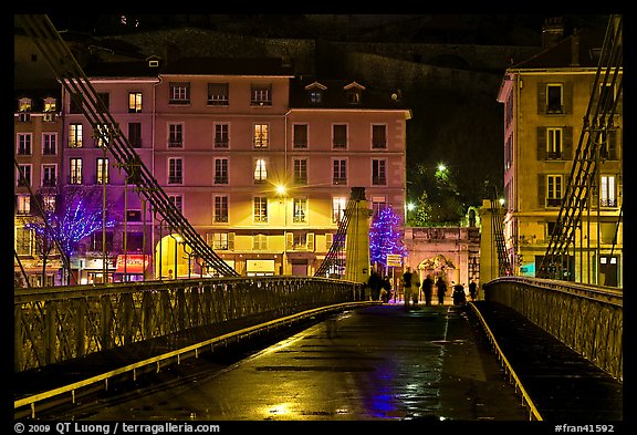 Pedestrians on suspension bridge at night. Grenoble, France (color)