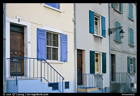 Facade of townhouses with colorful shutters. Arles, Provence, France