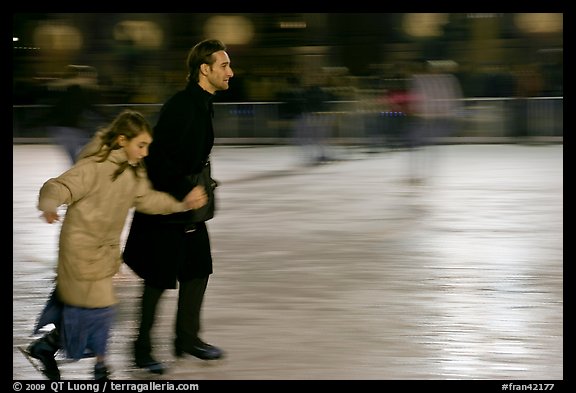Man skating with daughter by night. Paris, France