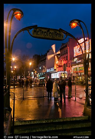 Art deco subway entrance and Moulin Rouge by night. Paris, France
