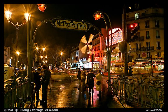 Metro entrance, boulevard, and Moulin Rouge on rainy night. Paris, France (color)