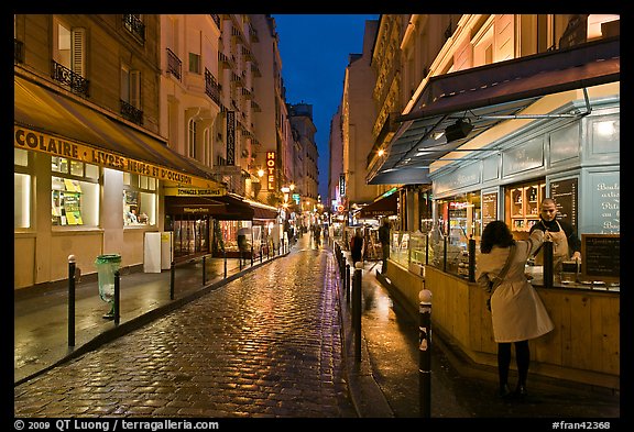 Woman buying food on street at night. Quartier Latin, Paris, France (color)