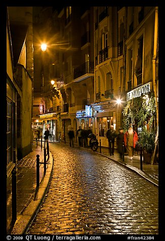 Cobblestone street with restaurants by night. Quartier Latin, Paris, France