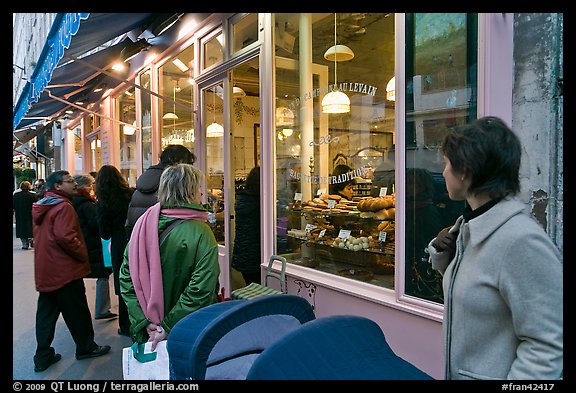 Customers wait in line in front of a popular bakery. Paris, France (color)