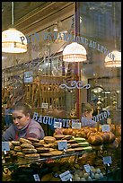 Woman selling pastries and bread in bakery. Paris, France