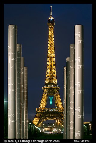 Columns of memorial to peace end Eiffel Tower by night. Paris, France (color)