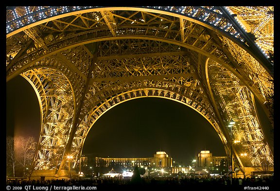 Palais de Chaillot seen through the base of Eiffel Tower by night. Paris, France (color)