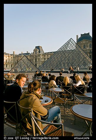 Couple sitting on terrace in Louvre main courtyard. Paris, France