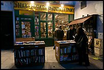People reading in front of bookstore at night. Quartier Latin, Paris, France (color)