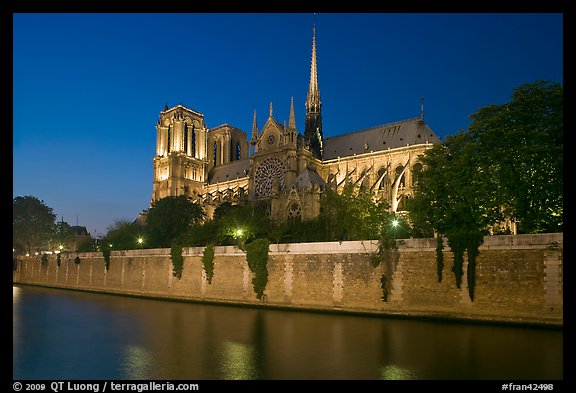 Side view of Notre Dame across Seine River at dusk. Paris, France