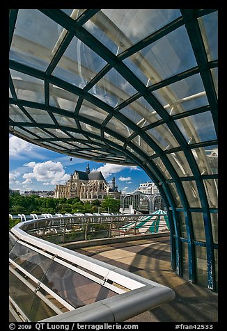 Curvy glass and metal structure framing historic Saint-Eustache church. Paris, France