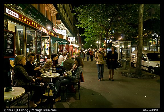 Cafe bar on sidewalk of a Grand Boulevard at night. Paris, France