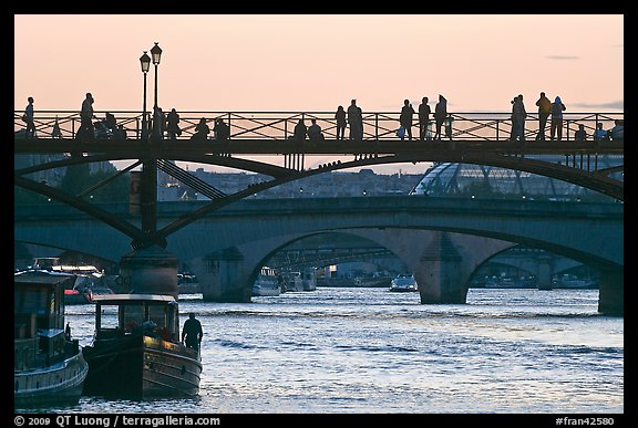 Seine river and people silhouettes on Pont des Arts. Paris, France