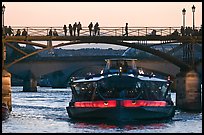 Tour boat below Pont des Arts at sunset. Paris, France