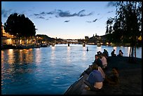People sitting on tip of Ile de la Cite at sunset. Paris, France ( color)