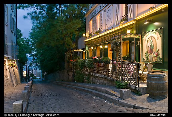 Cobblestone street and restaurant at dusk, Montmartre. Paris, France