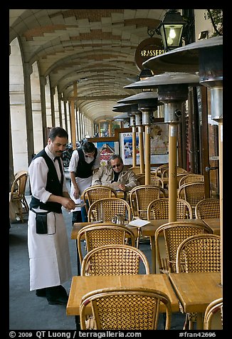 Waiters and customer, place des Vosges arcades. Paris, France