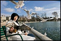 Elderly woman and seagulls, Tuileries garden. Paris, France (color)