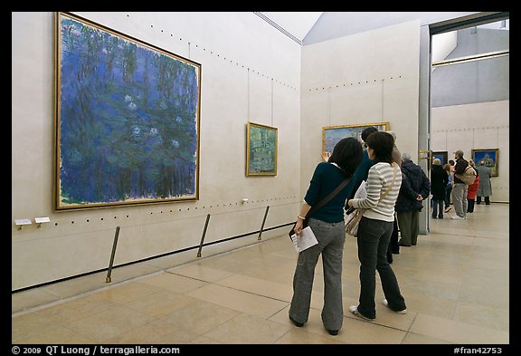 Tourists looking at a large impressionist painting of a lilly pond. Paris, France