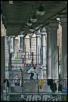 Youngsters skateboarding below metro bridge. Paris, France