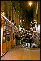 People walking in pedestrian street at night. Quartier Latin, Paris, France