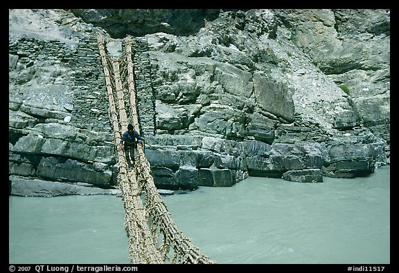 Man crossing a river by rope bridge, Zanskar, Jammu and Kashmir. India