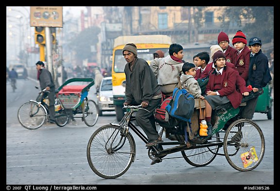 Cycle-rickshaw with a load of ten schoolchildren. New Delhi, India (color)