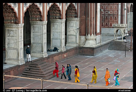 Women in colorful sari walking towards prayer hall, Jama Masjid. New Delhi, India