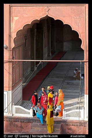 Women standing beneath arched entrance of prayer hall, Jama Masjid. New Delhi, India (color)