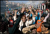 Young men celebrating and spraying wedding party in the street. Jodhpur, Rajasthan, India (color)