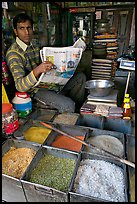 Man with newspaper selling grains, Sardar Market. Jodhpur, Rajasthan, India (color)