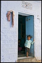 Young boy in doorway of house painted light blue. Jodhpur, Rajasthan, India (color)