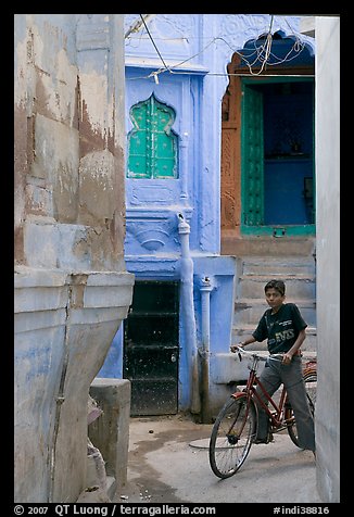 Boy riding a bicycle in a narrow old town street. Jodhpur, Rajasthan, India (color)