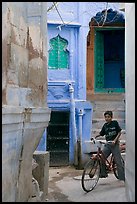 Boy riding a bicycle in a narrow old town street. Jodhpur, Rajasthan, India ( color)
