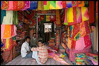 Men in shop selling colorful fabrics, Sardar market. Jodhpur, Rajasthan, India (color)
