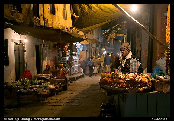 Flower vendor in  narrow old city alley at night. Varanasi, Uttar Pradesh, India