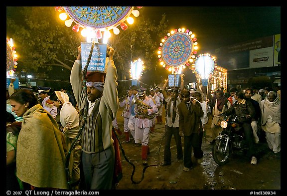 Men carrying bright electric signs during wedding procession. Varanasi, Uttar Pradesh, India