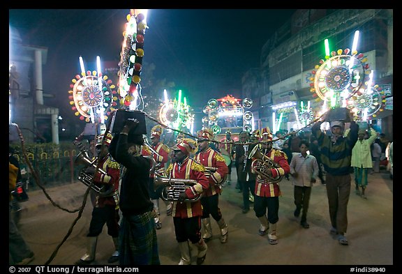 Musicians, men carrying lights, and carriage during wedding procession. Varanasi, Uttar Pradesh, India