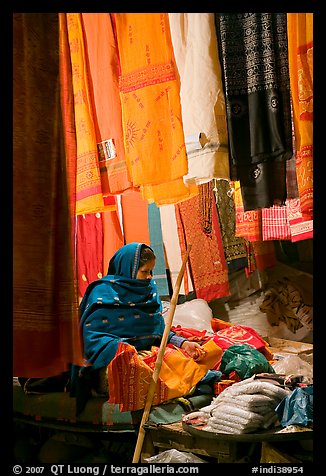Woman selling fabrics at night. Varanasi, Uttar Pradesh, India