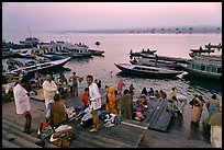 Men preparing for ritual bath on banks of Ganges River at dawn. Varanasi, Uttar Pradesh, India (color)
