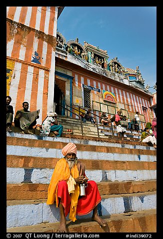 Holy man sitting on temple steps, Kedar Ghat. Varanasi, Uttar Pradesh, India (color)