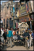 Man moving devotional image and children on rickshaw. Varanasi, Uttar Pradesh, India ( color)