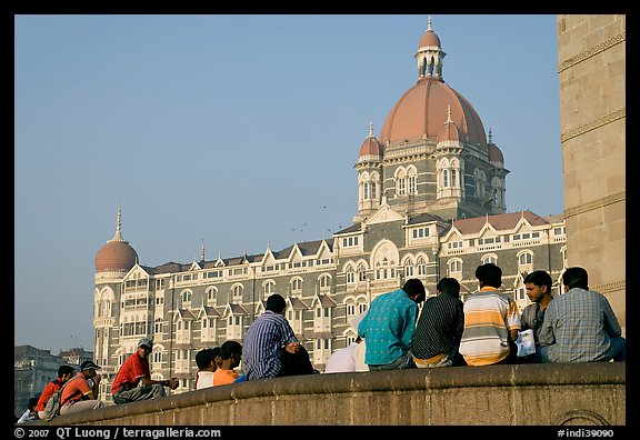 Men sitting in front of Taj Mahal Palace Hotel. Mumbai, Maharashtra, India