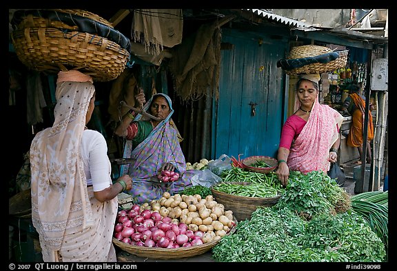 Women with baskets on head buying vegetables, Colaba Market. Mumbai, Maharashtra, India (color)