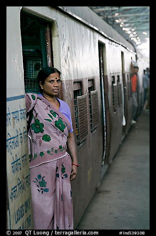 Woman standing at door of suburban train. Mumbai, Maharashtra, India