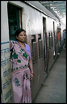Woman standing at door of suburban train. Mumbai, Maharashtra, India ( color)