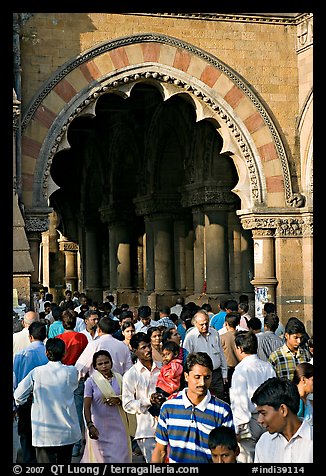 Crowd pass beneath an archway, Chhatrapati Shivaji Terminus. Mumbai, Maharashtra, India (color)