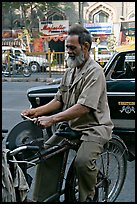 Man sharpening knifes on the street, Colaba. Mumbai, Maharashtra, India (color)